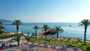 a view of a beach with chairs and palm trees at AQI Hydros Club in Kemer