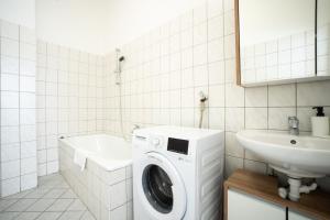 uma casa de banho com uma máquina de lavar roupa e um lavatório em Lovely 2-bedroom apartment next to Praterstern em Viena