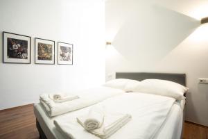 um quarto com uma cama com lençóis brancos e toalhas em Lovely 2-bedroom apartment next to Praterstern em Viena