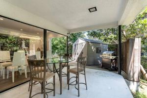 a screened in porch with a glass table and chairs at Multiview Manor in Los Angeles