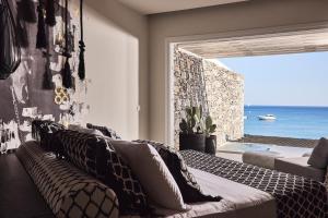 a living room with a couch and a view of the ocean at Artemis Seaside Resort in Paliochori