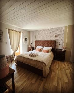 1 dormitorio con 1 cama grande y suelo de madera en Suite partner, en Peyriac-Minervois