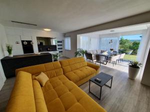 a living room with a yellow couch and a table at Little Getaway in Veliki Broćanac