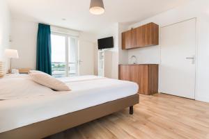 1 dormitorio blanco con 1 cama grande y TV en Appart'hotel Victoria Garden Pau en Pau