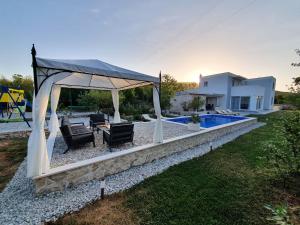 a backyard with a gazebo and a pool at Little Getaway in Veliki Broćanac
