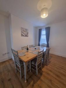 uma sala de jantar com uma mesa de madeira e cadeiras em Highly Modern home, 3 bed, close to the Lake District em Barrow in Furness