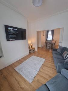 uma sala de estar com um sofá azul e uma televisão de ecrã plano em Highly Modern home, 3 bed, close to the Lake District em Barrow in Furness