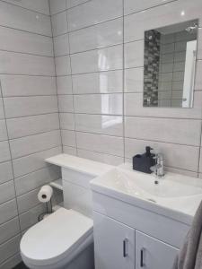 a white bathroom with a toilet and a sink at Highly Modern home, 3 bed, close to the Lake District in Barrow in Furness