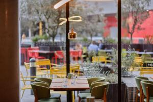 a restaurant with a table and chairs and a window at Aloft London Excel in London