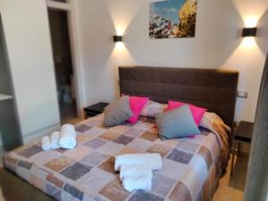 泰爾莫利的住宿－Sea Garden Rooms，一间卧室配有一张大床,配有粉色和蓝色的枕头