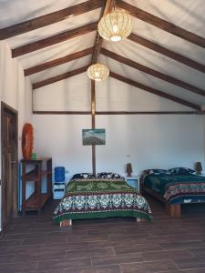 1 dormitorio con 1 cama en una habitación con techos de madera en Café Madame en Puerto López