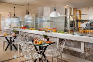 a restaurant with two tables and chairs with food at AQI Hydros Club in Kemer