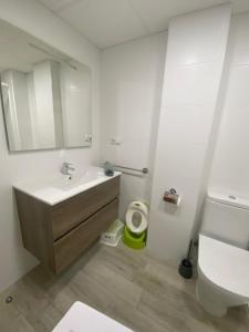 a white bathroom with a sink and a toilet at Apartamento Nuevo MannA in Oropesa del Mar +15 photos