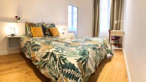 Le Saint Rome - Toulouse Hypercentre في تولوز: غرفة نوم بسرير لحاف أخضر وأصفر