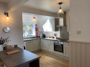 a kitchen with white cabinets and a counter top at 'Sandy Bottom' Broadstairs by the beach in Broadstairs