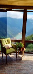 a green chair sitting on a porch with a table at Yesil Kosk Hotel in Uzungol