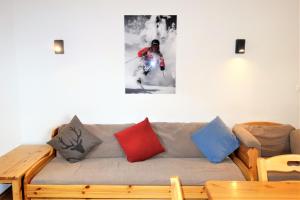 - un canapé avec des oreillers colorés dans le salon dans l'établissement Pracondu RENOVE OUTDOOR & FUN appartement 2 chambre 6 personnes, à Nendaz