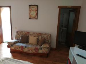 sala de estar con sofá y reloj en la pared en Estudio Brisa Canaria en Playa del Hombre