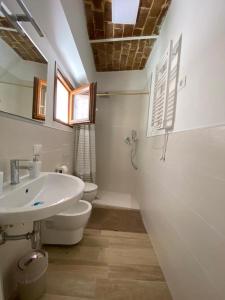 a white bathroom with a sink and a toilet at La cattedrale del mare in Termoli