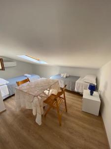 a white room with a table and two beds at La cattedrale del mare in Termoli