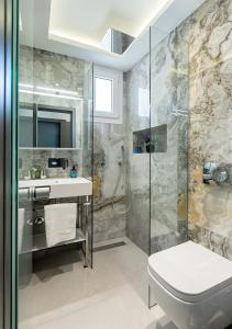 a bathroom with a shower and a toilet and a sink at SUN RESIDENCE Exclusive Seaside Suites in Polykhrono