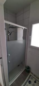 a shower with a glass door in a bathroom at Maison ville agréable in Riorges