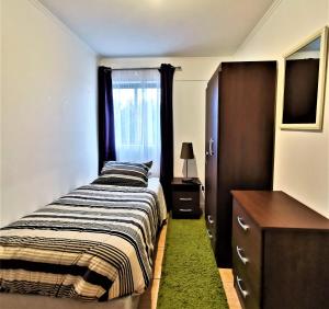 Un dormitorio con una cama y una cómoda y una ventana. en Hostal Vivo Concepción, en Concepción