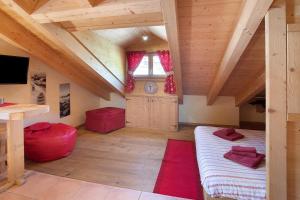 a large attic room with wooden ceilings and a window at La Baitina app C in Livigno