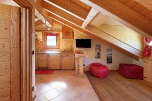 a large room with a kitchen with a vaulted ceiling at La Baitina app C in Livigno
