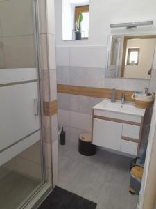 een badkamer met een wastafel en een spiegel bij Kaland apartman II. in Sátoraljaújhely