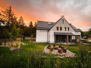 a white house with a fire pit in front of it at Vila Rasola in Malá Morávka