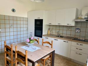 a kitchen with a wooden table with a vase of flowers on it at Cà Framari - Casa Vacanze in Marciaga