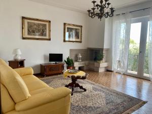 a living room with a yellow couch and a tv at Cà Framari - Casa Vacanze in Marciaga