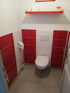 La salle de bains est pourvue de toilettes avec du carrelage rouge et blanc. dans l'établissement Appartement de plain pied dans la verdure, à Yerres