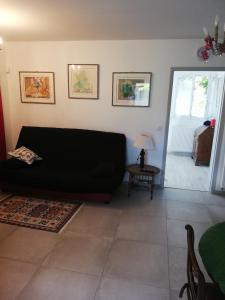 sala de estar con sofá negro y mesa en Appartement de plain pied dans la verdure, en Yerres