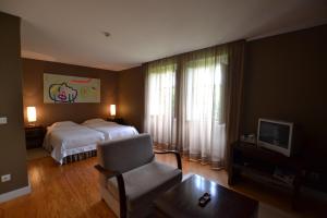 a hotel room with a bed and a chair at Casa do Campo - Turismo de Habitação in Celorico de Basto