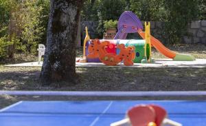 Un parque infantil con un tobogán y un árbol. en Belvedere del lago, en Montefiascone
