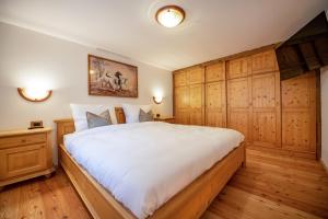 a bedroom with a large bed with wooden cabinets at Apartments Berna in Ortisei