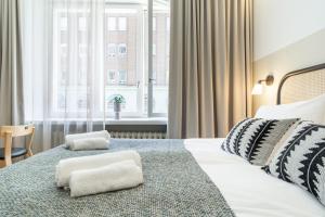 ヘルシンキにあるBob W Kluuviのベッドと大きな窓が備わるホテルルームです。