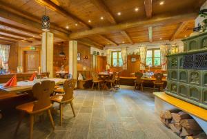 a dining room with tables and chairs and wooden ceilings at Berghotel Hammersbach in Grainau