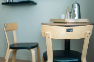 2 chaises assises à côté d'une table avec un lavabo dans l'établissement Bob W Kluuvi, à Helsinki