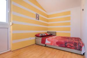 sypialnia z żółtymi i białymi paskami na ścianie w obiekcie Tina w Puli