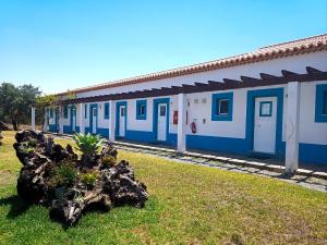 uma estação de comboios azul e branco com uma planta na relva em Dias Distintos - Turismo Rural em Colos