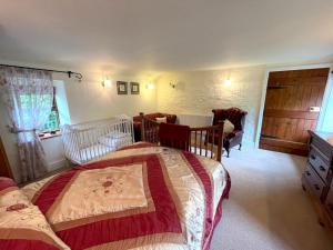 1 dormitorio con 1 cama, mesa y sillas en Pass the Keys Beautiful Scottish Cottage in Outstanding Location, en Sanquhar