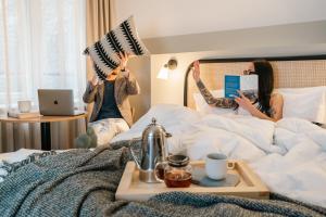 Due donne che saltano su un letto con le mani in alto di Bob W Kluuvi a Helsinki