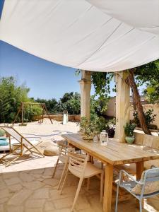 a wooden table and chairs under a white umbrella at Masia Rosalia in L'Aldea +30 photos
