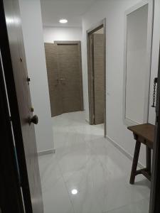 pasillo con suelo de baldosa blanca y puerta en Bergantin 8, en Torrevieja