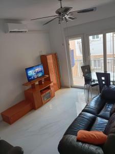 uma sala de estar com um sofá e uma televisão de ecrã plano em Bergantin 8 em Torrevieja