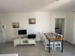 a living room with a table and a television at Apartments Andrea in Stara Novalja +64 photos