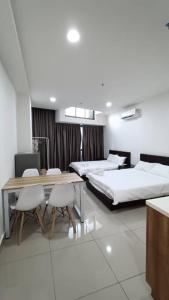 a bedroom with two beds and a table and chairs at Pacific Towers Star Seksyen 13 PJ Jaya One Parking Netflix Pool Kitchen in Petaling Jaya